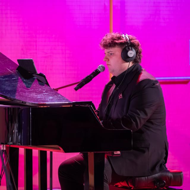 Julian Kokociński – pianista grający na scenie.